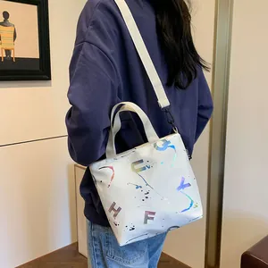 Detailed view of white canvas crossbody bag with artistic colorful gradient lettering