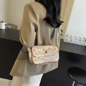 Detailaufnahme der Crossbody-Tasche mit Wellenmuster, gewebtem Gurt und Lederbesatz
