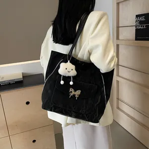 Detailed view of a black pleated tote bag with a butterfly buckle and white cloud charm
