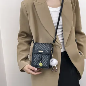 Chic black leather and canvas mini crossbody bag with a cute monster plush pendant