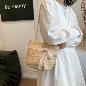 Detalle del bolso de paja hecho a mano con encaje blanco delicado y adorno de lazo
