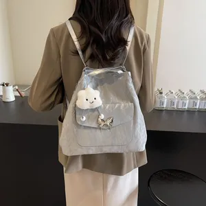 Detail of silver metallic backpack with butterfly metal buckle and cloud plush charm