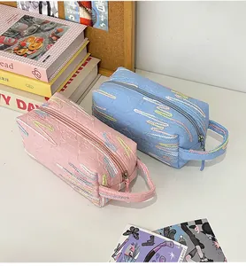 Detail van roze en blauwe tassen met kleurrijk golfborduurwerk en ritssluiting erop