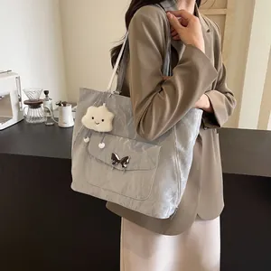 Detail of silver metallic pleated tote bag with butterfly buckle and cloud charm
