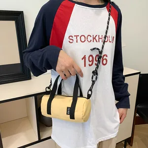Detailed view of mini yellow cylinder crossbody bag with adjustable woven strap on model