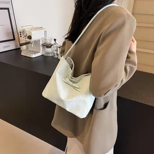 Détail du sac bandoulière vert menthe avec nœud décoratif et texture plissée sur la lanière