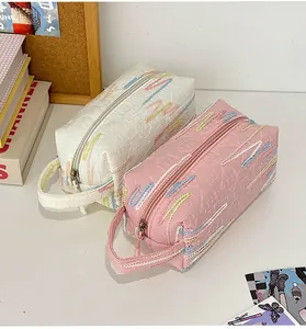 Detail van geborduurd golfpatroon en textuurstof op de cosmetische tas met ritssluiting