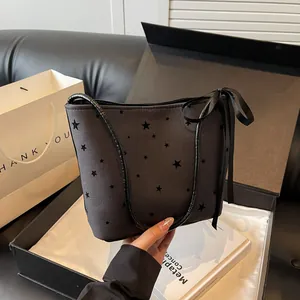 Detail van donkergrijze canvas tas met sterrenprint en strik in luxe geschenkdoos
