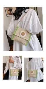 Detail of woven straw crossbody bag with white daisy ornament and green trim accents