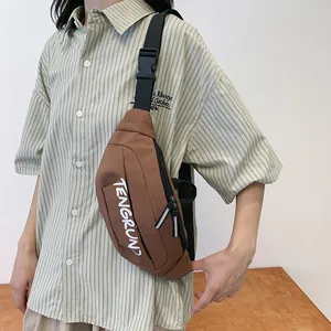 Detail of the dark brown nylon chest bag with tactical buckle and brand logo