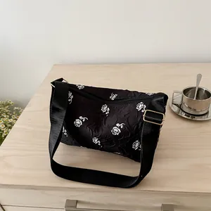 Floral shoulder bag with white roses on black pleated fabric and wide nylon strap