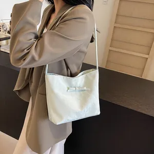 Détail du sac à bandoulière vert clair plissé avec nœud et tissu texturé doux