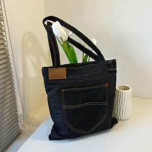 Large capacity navy denim tote bag with brown leather label and orange stitching detail