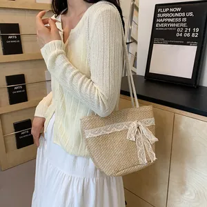 Detalle de bolso de hombro de paja beige con encaje blanco y lazo en ambiente de vida