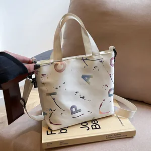 Close-up of a white nylon crossbody bag with artistic colorful graffiti print and dual handles