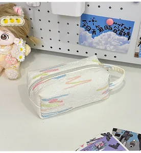 Detail van witte getextureerde clutch met pastel borduurwerk en handige zijhandgreep