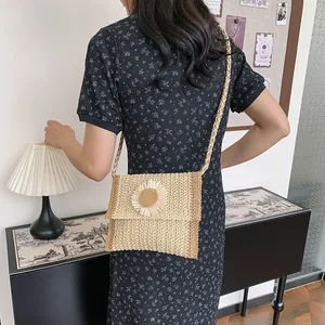 Detail of straw crossbody bag with sunflower accent worn by model in rural style