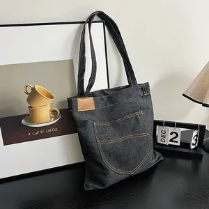 Dark grey denim tote bag with contrast orange stitching and retro casual shoulder style