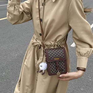 Close-up of vintage brown leather phone bag with geometric pattern and fashion logo