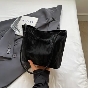 Détail d'un sac à main noir plissé avec un nœud élégant et une texture raffinée