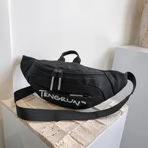 Detail of black nylon chest bag with white TENGRUN text and reflective zippers