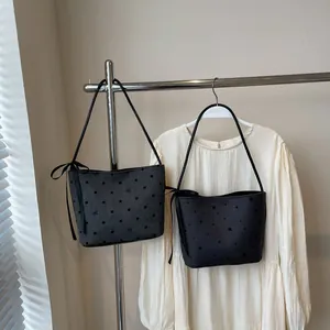 Detail van canvas emmertassen met polkadot- en stermotieven met lintaccenten