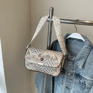 Detail der Schultertasche mit Bergmuster, geometrischem Gurt und brauner Verschluss-Schnalle