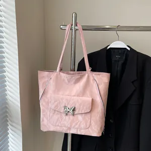 Detailed macro of pink pleated tote bag featuring a silver metal butterfly buckle