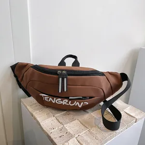 Detail view of brown nylon crossbody bag with dual zippers and white TENGRUN logo