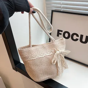 Detalle del bolso de paja tejido con ribete de encaje y un dulce lazo de encaje decorativo