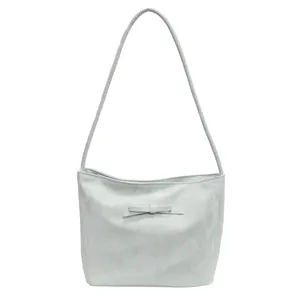 Sac à bandoulière bleu clair plissé avec nœud délicat sur fond blanc épuré
