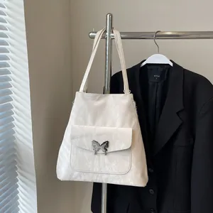 Detail of cream tote bag with marble texture and silver butterfly metal buckle