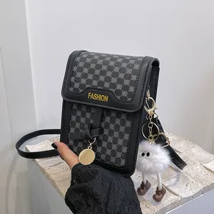 Close-up of a vintage pattern mini crossbody bag with a plush doll and stone background