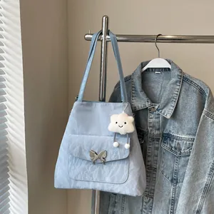 Close-up of light blue shoulder bag with silver butterfly buckle and cloud charm