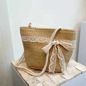 Detalle del bolso de paja tejida con ribete de encaje blanco y asas de cuerda de algodón