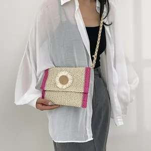Detail of handmade straw crossbody bag featuring a 3D sunflower and pink trim finish