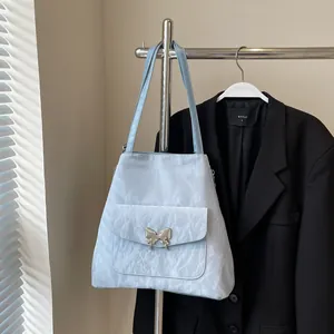 Detail of light blue nylon tote bag with silver butterfly buckle on front pocket