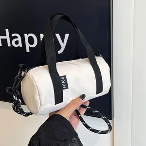 Close-up of white oxford fabric mini cylinder bag with black strap and woven cord