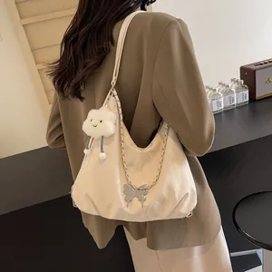 Close-up of a large cream tote bag with silver butterfly and plush cloud charms