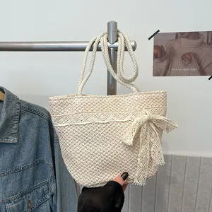 Detalle de un bolso de paja hecho a mano con encaje beige y diseño de lazo elegante