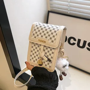 Detail of cream mini crossbody bag with black polka dots and white plush monster charm