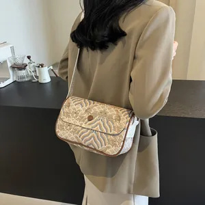 Moderne Umhängetasche im China-Stil mit Wellenstickerei und breitem Gurt am Modell