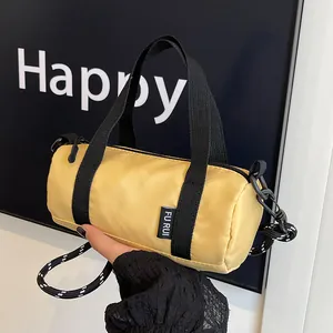 Detail of yellow mini cylinder bag featuring Oxford fabric and thick rope shoulder strap