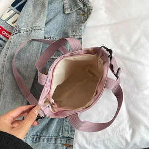 Pink heart print crossbody bag with spacious interior and purple woven strap for women
