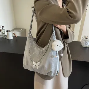 Detail of silver metallic tote bag with butterfly pendant and fluffy cloud charm