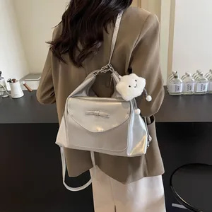 Detail van zilveren tote bag met strik en een witte pluchen wolk bedeltje als accessoire