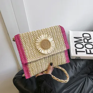 Detailed close-up of straw woven crossbody bag with pink trim and 3D sunflower accent
