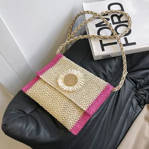 Detail of handwoven straw bag with sunflower ornament and woven crossbody strap