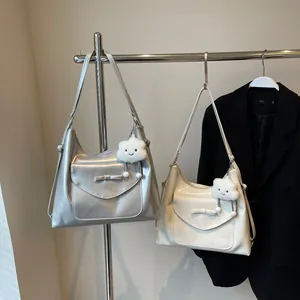 Detail van metallic zilveren en crème draagtassen met strikflap en pluche wolkbedels