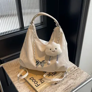 Detail of silver textured hobo bag featuring butterfly chain and plush cloud charm